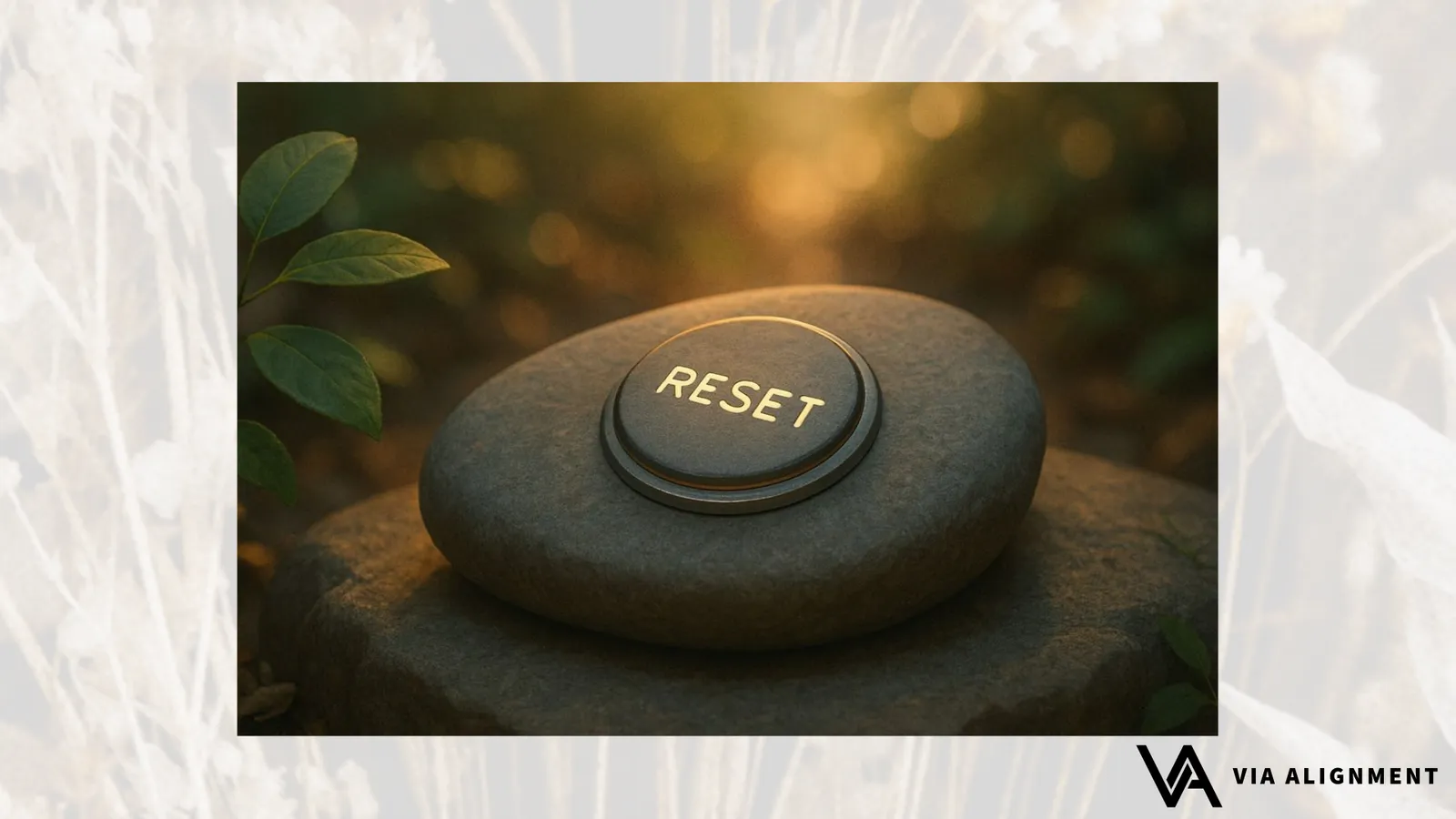 A smooth stone engraved with the word "RESET" rests on a larger rock outdoors, backlit by warm evening light among green leaves.