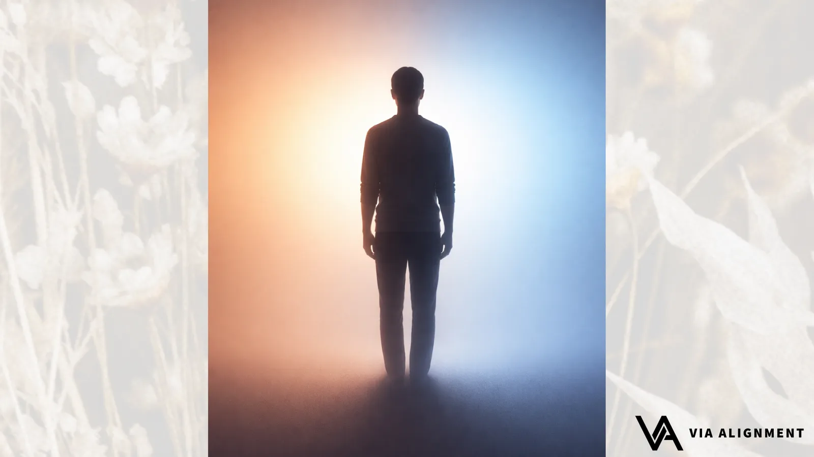 A man in silhouette stands centered where warm orange light meets cool blue light, the two tones blending softly behind him.